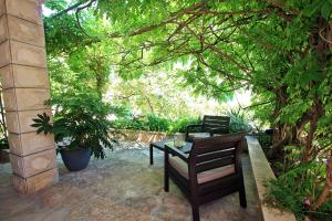 a patio with a table and chairs under a tree at Apartment Zorica in Supetar