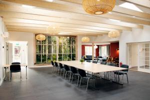 una grande sala da pranzo con un grande tavolo e sedie di Feriebyens Bed & Breakfast a Rødvig