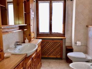 bagno con lavandino, servizi igienici e finestra di Chalet Bormino a Bormio