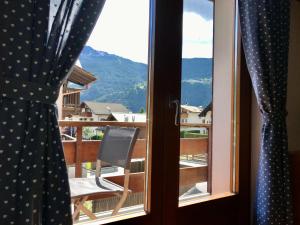 een uitzicht vanuit een raam met een stoel op een balkon bij Chalet Bormino in Bormio
