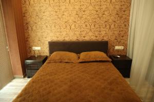 een slaapkamer met een groot bed met 2 nachtkastjes bij Comfort Lux in Tbilisi City