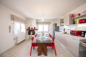 una cocina con mesa y sillas rojas. en Il Cortiletto - Appartamento Lores, en Manerba del Garda