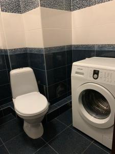 een badkamer met een toilet en een wasmachine bij Квартира в новострое in Odessa