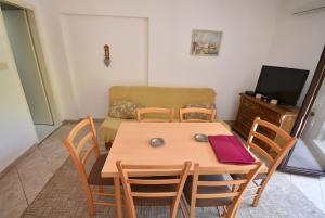 a dining room with a table and chairs and a couch at Igalo Garden Apartment in Herceg-Novi