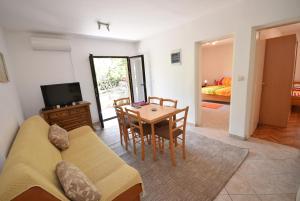 a living room with a couch and a table at Igalo Garden Apartment in Herceg-Novi