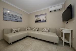 sala de estar con sofá y TV de pantalla plana en Villa Luka Lopar, en Lopar