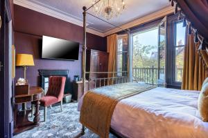 a bedroom with a bed and a tv on a wall at Clementine's Town House Hotel BW Premier Collection in York