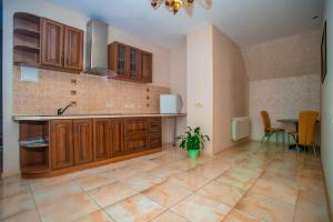 Una cocina grande con gabinetes de madera y una mesa. en Отель Корона, en Dnipro 24 fotos más