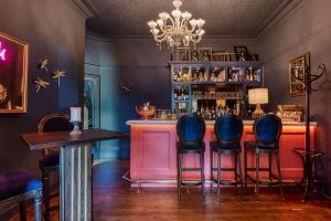 a bar with blue chairs in a room at Clementine's Town House Hotel in York