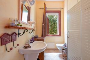 bagno con lavandino, servizi igienici e specchio di Pedra De Mari a Pula