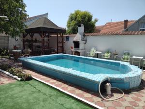 a swimming pool in a backyard with a gazebo at Ćane Rooms in Bela Crkva