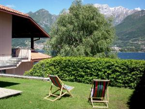 two chairs sitting in the grass next to a house at La Spiaggia in Oliveto Lario