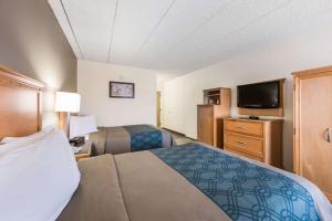 a hotel room with two beds and a flat screen tv at Econo Lodge Quakertown in Quakertown