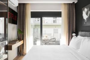 - une chambre avec un lit blanc et un balcon dans l'établissement LUX&EASY Athens Downtown Apartments, à Athènes