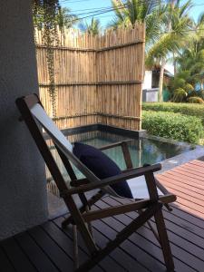a wooden chair sitting on a deck next to a pool at Jasmine & Tea House in Mae Nam