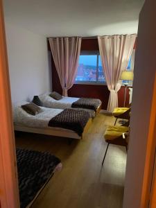 ル・テュケ・パリ・プラージュにあるLe Rayon Vertのベッドルーム1室(ベッド2台付)、窓(カーテン付)