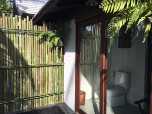 a toilet outside of a house with a fence at Jasmine & Tea House in Mae Nam