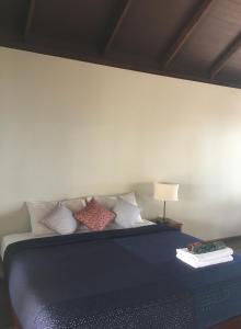 a bedroom with a blue bed with pillows at Jasmine & Tea House in Mae Nam