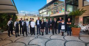 un grupo de hombres parados frente a un edificio en Sardegna Hotel - Suites & Restaurant, en Cagliari