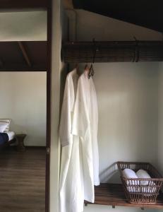 a robe hanging on a rack in a bedroom at Jasmine & Tea House in Mae Nam
