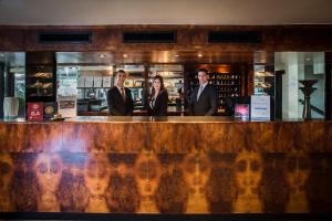 a group of three people standing at a bar at Sardegna Hotel - Suites & Restaurant in Cagliari