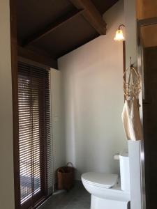 a bathroom with a toilet and a window at Jasmine & Tea House in Mae Nam