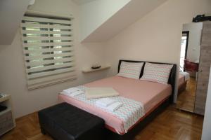 een kleine slaapkamer met een bed en een raam bij Apartmani Dijana 2 in Kotor