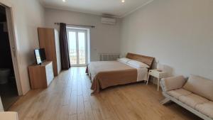 1 dormitorio con 1 cama y 1 sofá en una habitación en Anaka sweet home, en Agrigento