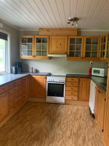 a kitchen with wooden cabinets and white appliances at Big house in amazing Napp, Lofoten in Napp