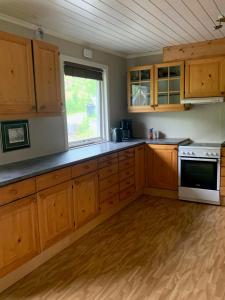 a kitchen with wooden cabinets and a window at Big house in amazing Napp, Lofoten in Napp