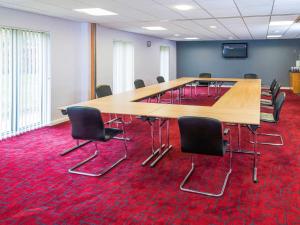 a room with a table, chairs, and tables at ibis Styles Barnsley in Barnsley