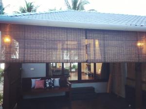 a room with a couch and a window with curtains at Jasmine & Tea House in Mae Nam