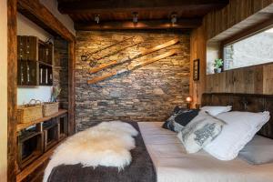 1 dormitorio con 1 cama con pared de piedra en Cal Cassi - Suite de muntanya, en Ger