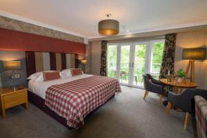 una camera d'albergo con un letto e una finestra di Craigmhor Lodge & Courtyard a Pitlochry