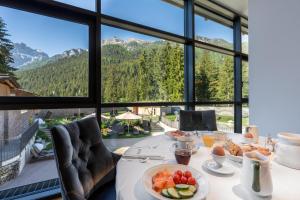 un tavolo per la colazione con vista sulle montagne di Croce Bianca Leisure & Spa Hotel a Canazei