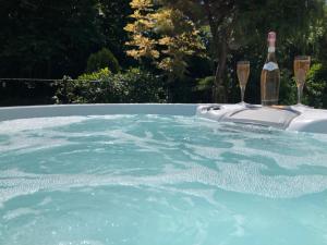 bañera de hidromasaje con botella de vino y 2 copas en Little Gem with Private Hot Tub - Up to 25 percent off ferry en Shanklin