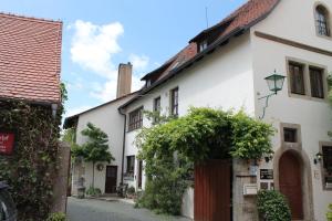 un callejón en una pequeña ciudad con casas blancas en Kreuzerhof Hotel Garni, en Rothenburg ob der Tauber
