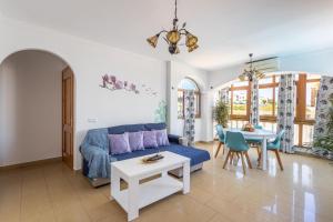 uma sala de estar com um sofá azul e uma mesa em Apartamento con piscina privada em Nerja