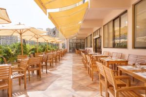 a restaurant with wooden tables and chairs and umbrellas at Rhactus Hotel, New Alamein in El Alamein