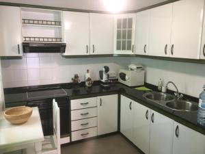 a kitchen with white cabinets and a sink at Casa Angeles in Santa Cruz de la Palma