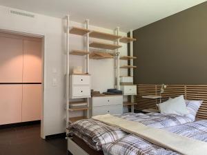 1 dormitorio con 2 camas, escritorio y estanterías en Ual da Flex (Ava 4) en Savognin