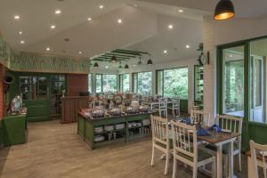 a restaurant with a dining room with tables and chairs at Club Mahindra Mount Serene, Munnar in Chinnakanal