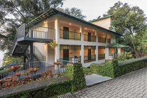 una imagen de una casa con balcón en Club Mahindra Mount Serene, Munnar, en Chinnakanal