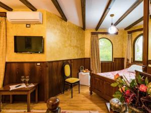 1 dormitorio con 1 cama y TV en la pared en Hotel Castle Park, en Berat