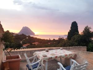 uma mesa e cadeiras numa parede com vista para o oceano em Pinelopi Room em Olbia