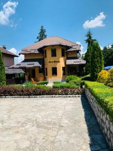 ein großes gelbes Haus mit steinerner Einfahrt in der Unterkunft Vila Darija Zlatar - LUX apartman br. 5 in Nova Varoš