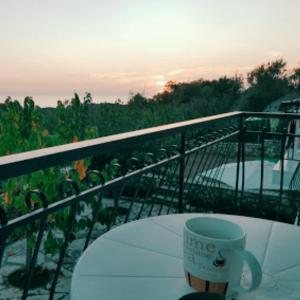 a cup of coffee sitting on a table on a balcony at Santa Maria Rooms in Agios Nikitas
