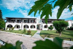 a large white building with a courtyard at Villa Flegos in Skala Fourkas