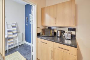 a kitchen with wooden cabinets and a microwave at Host & Stay - The Gallery Apartments in Scarborough +13 photos