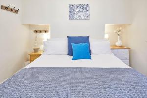 a bedroom with a bed with blue and white pillows at Host & Stay - The Gallery Apartments in Scarborough